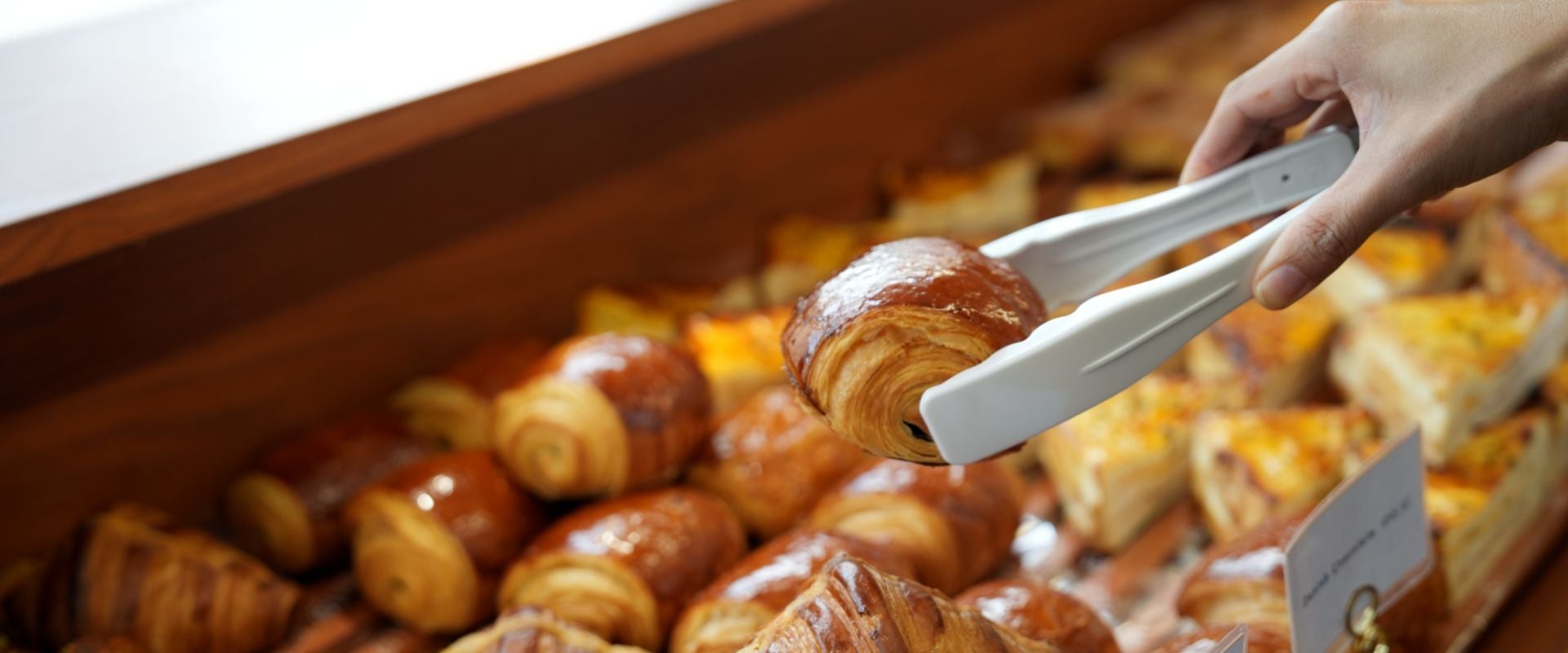 person picking up pastry with tongs