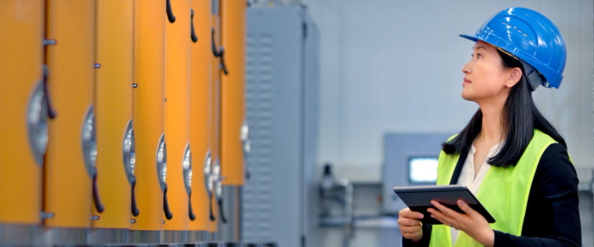 woman inspecting factory machine