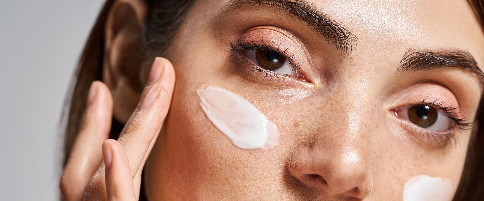woman applying make to her face