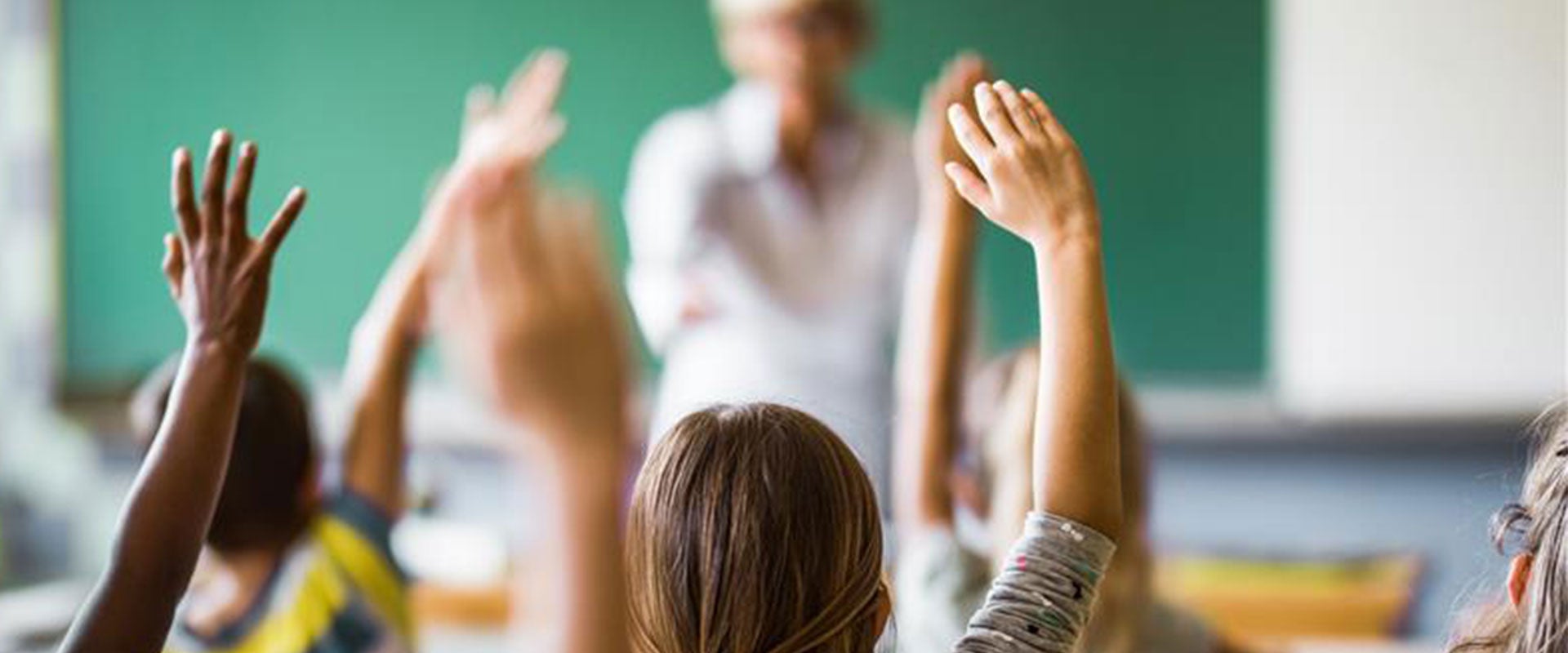 students raising hand in classroom