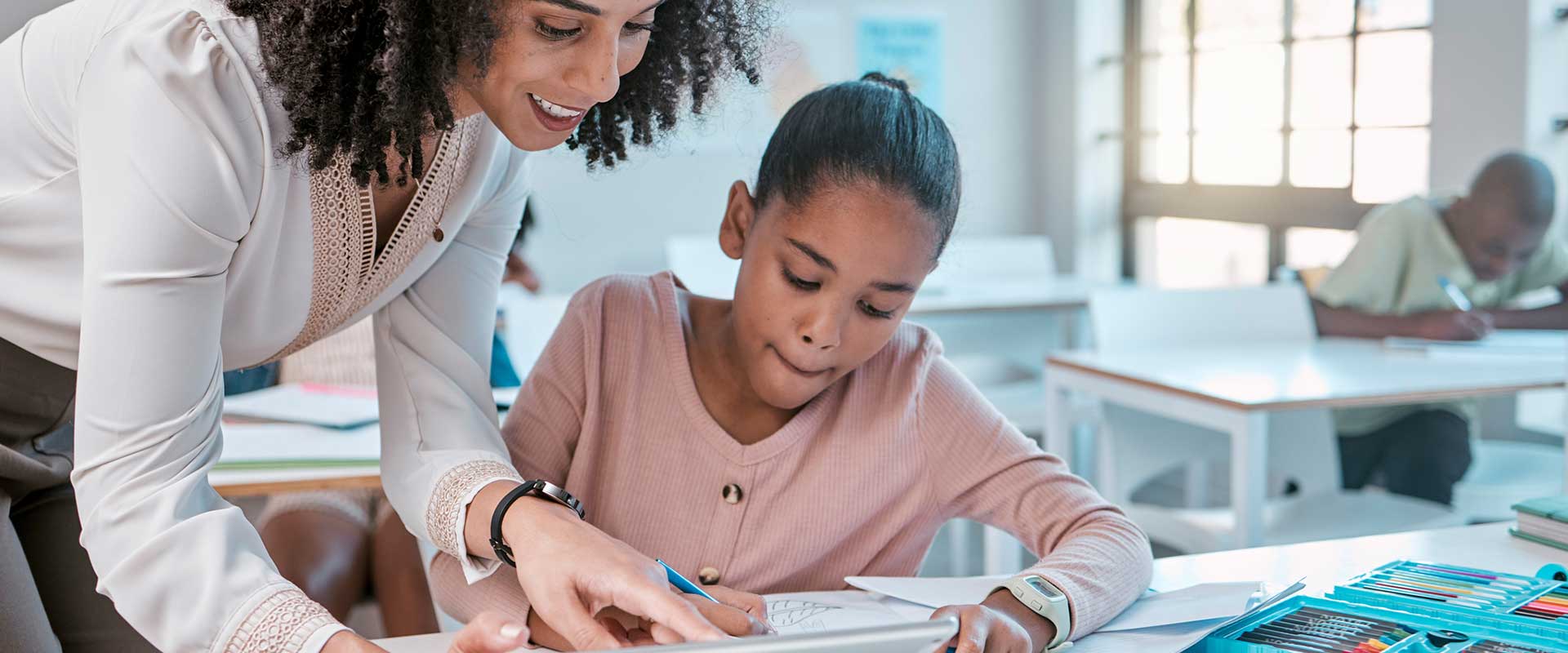 teacher and young student in classroom
